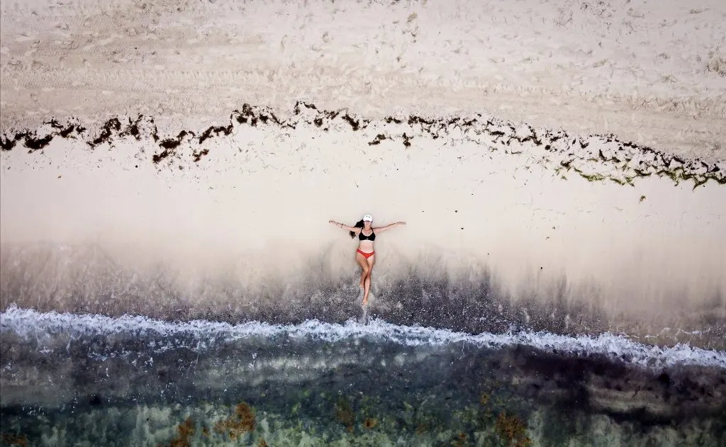 woman laying on a beach drone shot